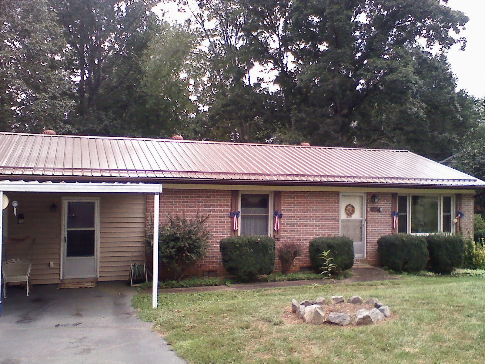 Bronze metal roof and carport on a brick ranch home — Roof Repair work by our crew in Adah
